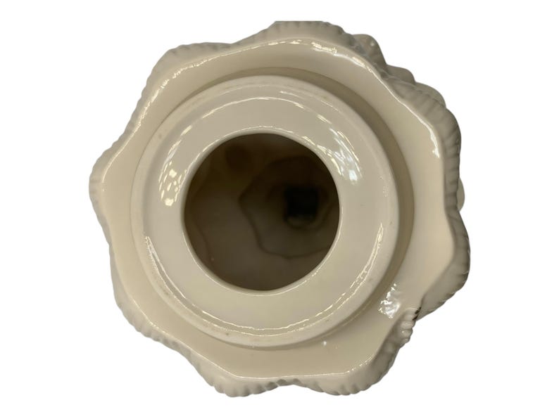 May include: White ceramic lidded jar with a textured, tree-like design. The lid is open, revealing the inside of the jar.