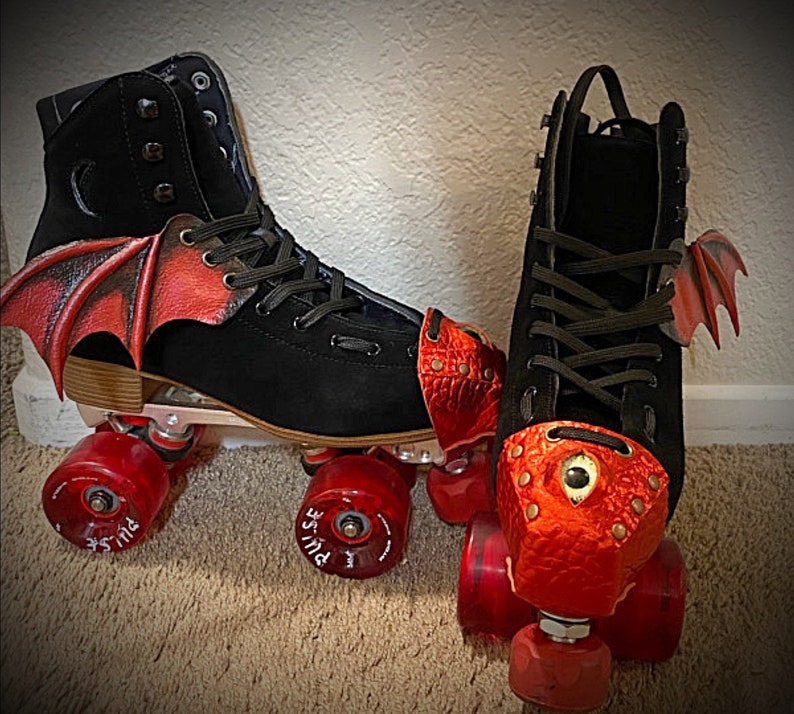 May include: A pair of black roller skates with red dragon-themed toe stops and wings. The skates have black wheels with red hubs and the words "PULSE" printed on the wheels.