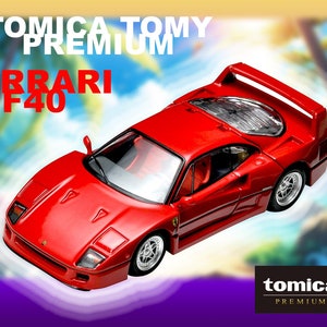 Könnte beinhalten: Ein rotes Tomica Premium Ferrari F40 Spielzeugauto mit schwarzen Akzenten und einem schwarzen Heckspoiler. Das Auto befindet sich auf einem lila und weißen Hintergrund mit Palmen.