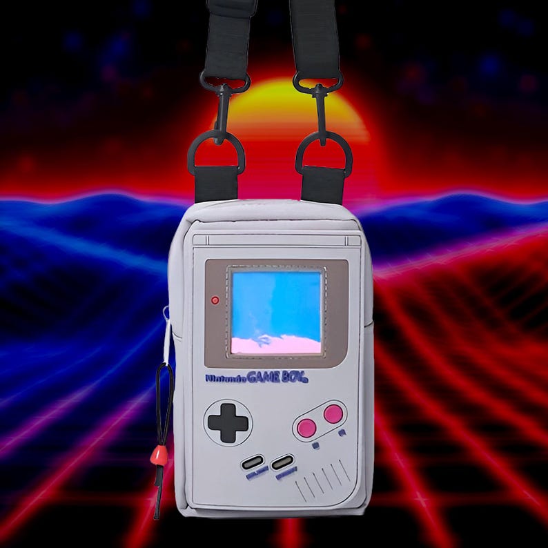 A white Game Boy-style crossbody bag with a purple and gray screen, a red button, and the text 'Nintendo GAME BOY'.