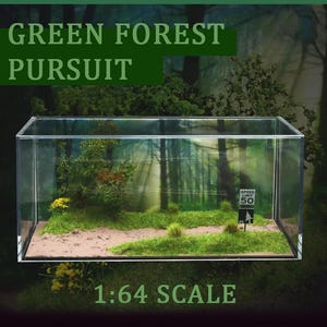 May include: A miniature diorama titled "Green Forest Pursuit" in a clear acrylic display case. The scene includes a forest backdrop, a dirt path, and miniature trees and grass. A small sign indicates a speed limit of 50. The scale is 1:64.