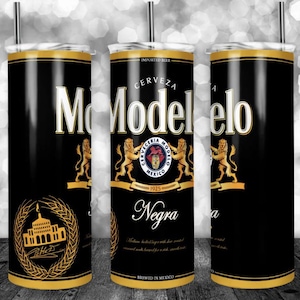 May include: A black and gold stainless steel tumbler with the Modelo Negra beer logo. The tumbler features a black background with gold lettering and a gold crest with a lion.