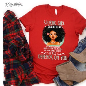 May include: Red t-shirt with a graphic of a black woman with an afro and the text "Scorpio Girl I Can Be Mean As Sweet As Candy Cold As Ice & Evil As Hell Or Loyal Like A Soldier It All Depends On You"