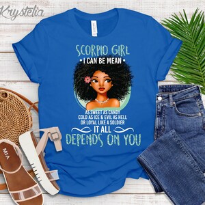 May include: Blue t-shirt with a graphic of a black woman with an afro and the text "Scorpio Girl &bull; I can be mean &bull; As sweet as candy cold as ice & evil as hell or loyal like a soldier It all depends on you"