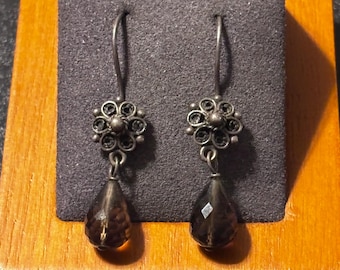 Pendiente colgante de plata de ley con filigrana floral y cuenta facetada de color marrón con forma de briolete.