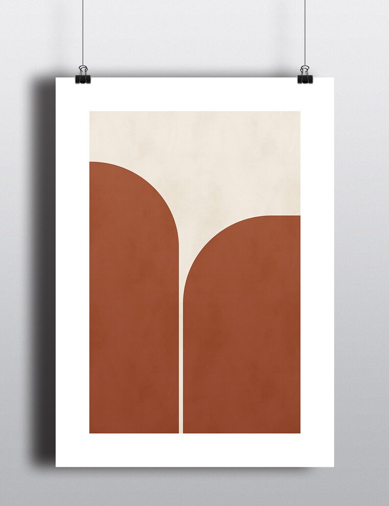 May include: Abstract art print with a geometric design featuring two rounded shapes in burnt orange and a smaller white shape in the center.