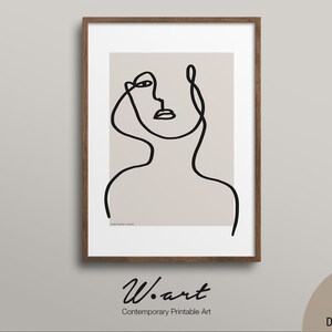 Può includere: Una stampa incorniciata con un disegno a tratto minimalista nero di un viso e un collo su sfondo beige. L'opera d'arte è in una cornice di legno marrone. La parte inferiore della stampa ha il testo "W. art Contemporary Printable Art".