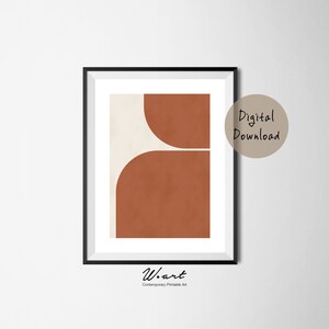 May include: Abstract geometric art print with a white and orange color scheme. The print features two overlapping rounded shapes, one white and one orange. The print is framed in a black frame.