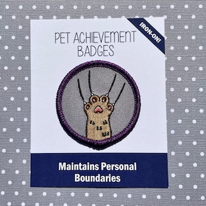 May include: Iron-on patch for pet achievement badges. The patch features a cartoon cat paw with claws extended and the text "Maintains Personal Boundaries".
