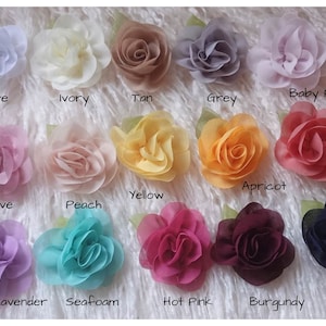 May include: Assortment of 15 small fabric flower embellishments in various colors, including white, ivory, tan, grey, baby pink, mauve, peach, yellow, apricot, coral, lavender, seafoam, hot pink, burgundy, and navy.