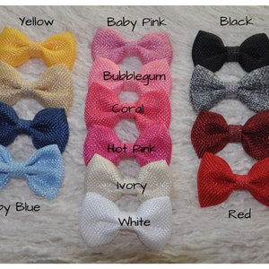 May include: A collection of 14 fabric bows in various colors, including tan, navy, yellow, baby pink, black, bubblegum, grey, coral, burgundy, hot pink, ivory, baby blue, red, and white.