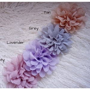 May include: Five fabric flower hair clips in different shades of pink, purple, and gray. The colors are labeled "Dusty", "Lavender", "Grey", "Tan", and "Dusty".