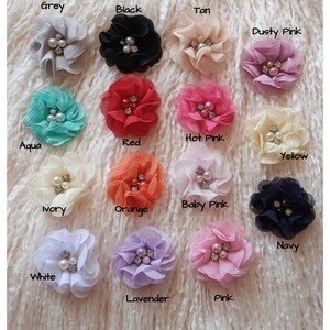 May include: Assortment of 15 fabric flower hair clips in various colors, including grey, black, tan, dusty pink, aqua, red, hot pink, yellow, ivory, orange, baby pink, navy, white, lavender, and pink. Each flower has a pearl center.
