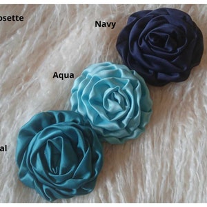 May include: Three 3-inch satin rosettes in teal, aqua, and navy blue.
