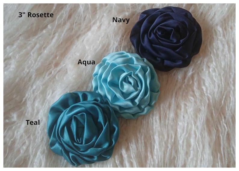 May include: Three 3-inch satin rosettes in teal, aqua, and navy blue.