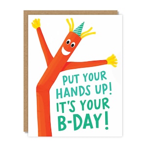 May include: A birthday card featuring an orange inflatable tube man with a party hat and the text "Put your hands up! It's your B-day!"