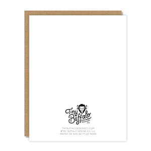 May include: A white greeting card with a brown border. The card features the Tiny Buffalo Designs Co. logo and text at the bottom. The text includes the website address and states the card is printed on 100% recycled paper.