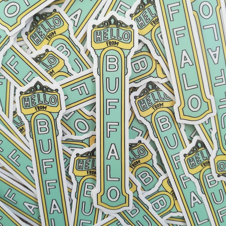 May include: A close-up of several stickers with the text "Hello from Buffalo" printed on them. The stickers are green and yellow and have a retro design.