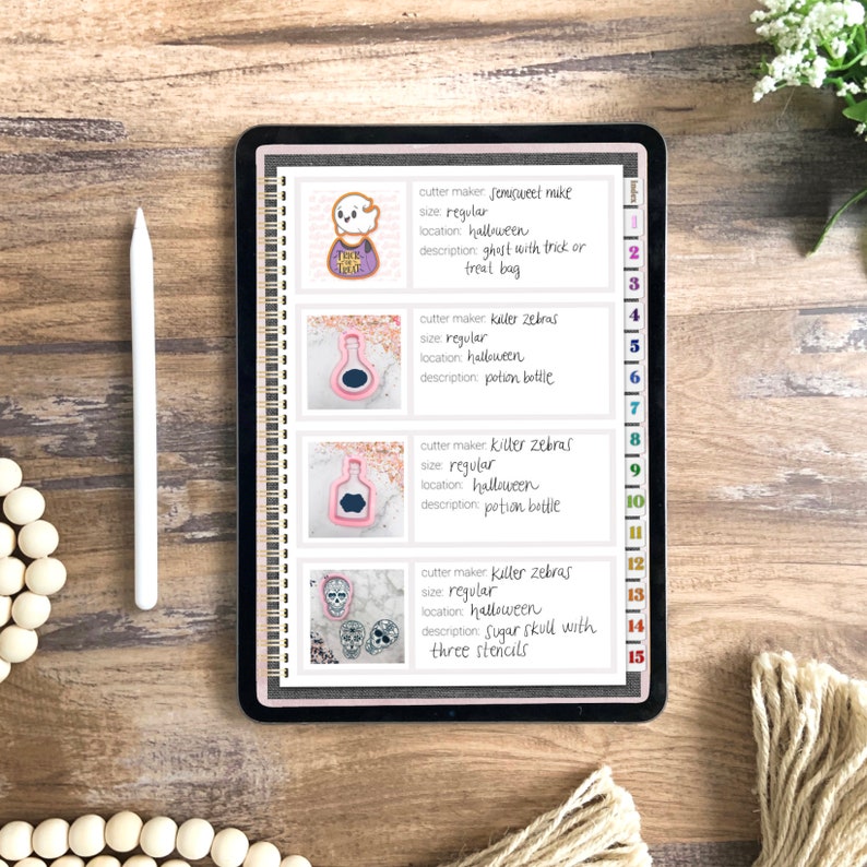 May include: A digital tablet screen displaying a list of Halloween cookie cutter designs. The designs include a ghost, a potion bottle, and a sugar skull. Each design is labeled with the cutter maker, size, location, and description.