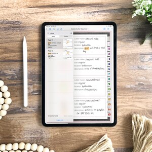 May include: A digital tablet screen displaying a list of cookie cutters for Halloween. The list includes the cutter maker, size, location, and description for each cutter. The list is organized by page number. The tablet is on a wooden surface.