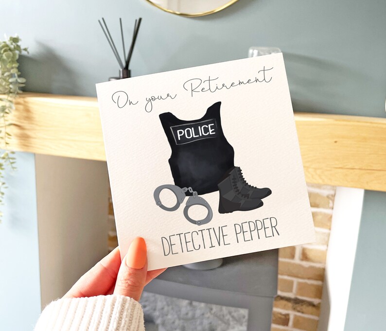 May include: A white card with the text "On your Retirement Detective Pepper" and a black police vest with the word "Police" on it, handcuffs, and a black boot.