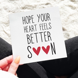 Pu&ograve; includere: Carta bianca con testo nero che dice "Spero che il tuo cuore si senta meglio presto" con due cuori rossi tra le parole "presto" e "N".