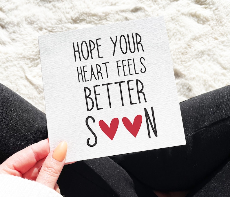 Pu&ograve; includere: Carta bianca con testo nero che dice "Spero che il tuo cuore si senta meglio presto" con due cuori rossi tra le parole "presto" e "N".