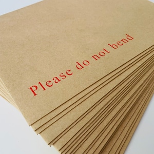 This photo shows a pile of Do Not Bend Envelopes which the cards are sent in.