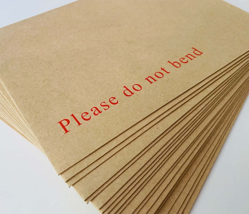 This photo shows a pile of Do Not Bend Envelopes which the cards are sent in.