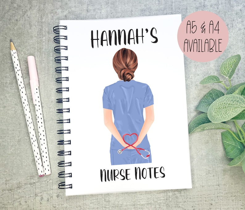 May include: A white spiral bound notebook with a blue and red illustration of a nurse with a stethoscope and the text "HANNAH'S NURSE NOTES" on the front.