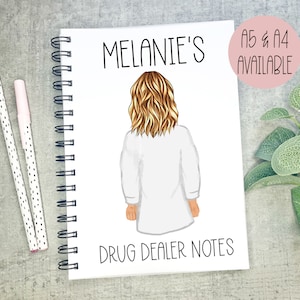 Peut inclure: Un carnet à spirales blanc avec le texte "Melanie's Drug Dealer Notes" imprimé sur la couverture. Le carnet présente une illustration de dessin animé d'une femme aux cheveux blonds portant une blouse blanche.