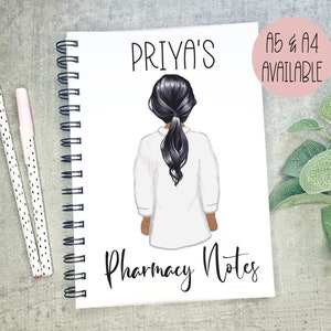 May include: A white spiral bound notebook with a black and white illustration of a woman with long black hair wearing a white lab coat. The text "PRIYA'S Pharmacy Notes" is printed on the front of the notebook. The text "A5 & A4 AVAILABLE" is printed in a pink circle on the right side of the notebook.
