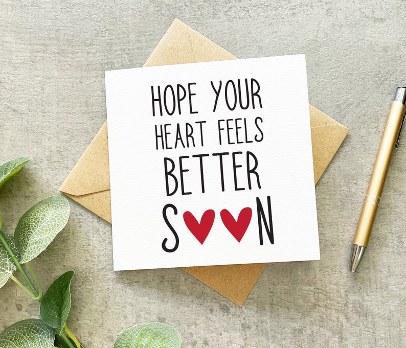 Pu&ograve; includere: Carta bianca con testo nero che dice "Spero che il tuo cuore si senta meglio presto" con due cuori rossi tra le parole "presto" e "meglio".