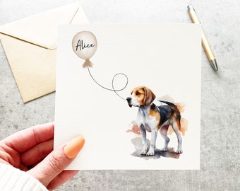May include: A white card with a watercolor illustration of a beagle dog looking up at a white balloon with the name "Alice" written on it.