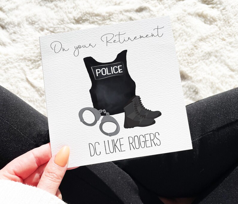 May include: A white card with black text that reads "On your Retirement" and a black and white illustration of a police officer's uniform, handcuffs, and boots. The text "DC LUKE ROGERS" is printed below the illustration.