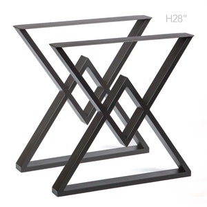 May include: Two black metal table legs in a criss-cross design. The legs are 28 inches tall and have a geometric shape.