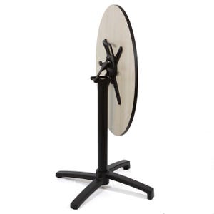 May include: A round, light-colored wooden table top is attached to a black metal base. The base has a central column and a four-legged star-shaped foot. The table is designed to fold for storage.