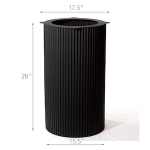 May include: A tall, black cylindrical planter with vertical ribbed detailing. The planter is 28 inches tall, 17.5 inches wide, and 15.5 inches deep. The top has a slightly flared rim. The planter is designed for outdoor or indoor use.