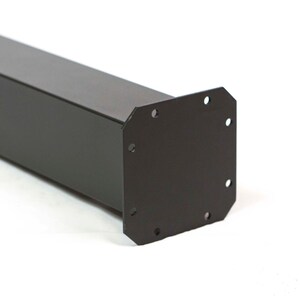 May include: A black metal post with a square profile and a mounting plate at one end. The mounting plate has six evenly spaced holes for secure attachment. The post is designed for structural support.