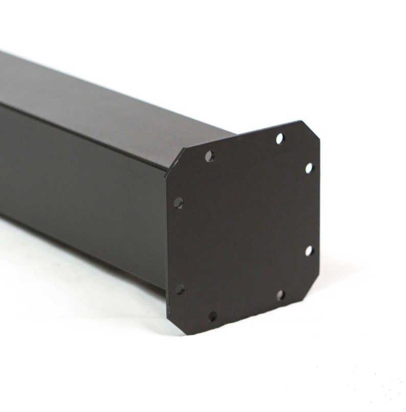 May include: A black metal post with a square profile and a mounting plate at one end. The mounting plate has six evenly spaced holes for secure attachment. The post is designed for structural support.