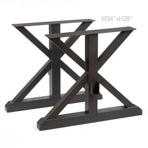 May include: Two black metal table legs with an X-shaped design. The legs are 86 cm wide and 71 cm high. W34" x H28"