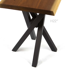 May include: A modern side table with a natural wood top and black metal legs. The table is 22 inches high. The legs are designed in an X-shape for stability and style. The wood top has a live edge.