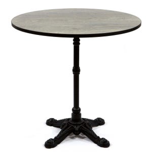 May include: A round bistro table with a dark gray wooden top and a black metal base. The base features a decorative, ornate design with four feet. The table's height is supported by a central black metal column.