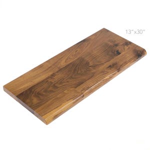 May include: A rectangular wooden shelf, measuring 33 cm x 76 cm, with a natural wood grain finish. The shelf has a smooth, polished surface and a warm, brown colour. The dimensions are visible in the image.