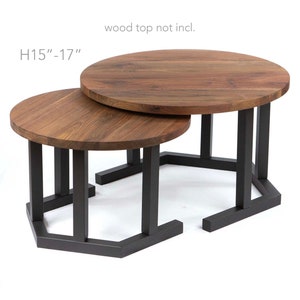 May include: Two round wooden coffee tables with black metal hexagonal bases. The tables are nested, with the smaller table on top of the larger table. The text "H15"-17" is printed on the image. The text "wood top not incl." is printed on the image.