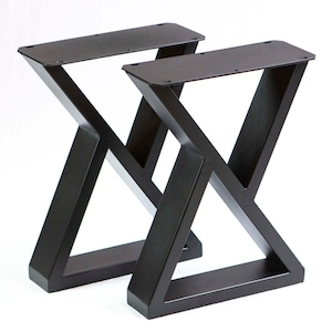 Peut inclure: Deux pieds de table en métal noir avec un design en forme de X. Les pieds sont en métal robuste et ont une finition noire poudrée.
