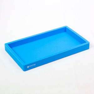 May include: A light blue silicone tray with a raised edge. The tray has the words "Rusty Design" printed on the bottom.