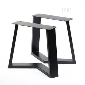May include: Two black metal table legs, each with a triangular shape and a height of 16 inches.  H16" is printed on the image.