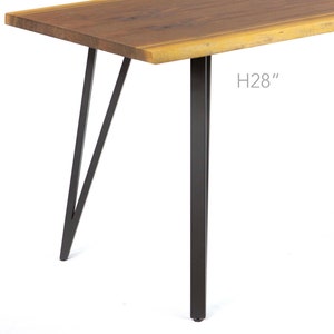 May include: A wooden table with a live edge top and black metal legs. The table is 71 cm tall.