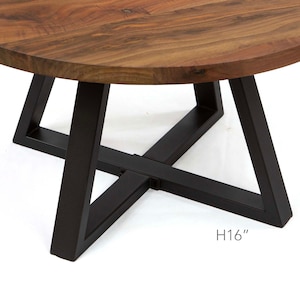 May include: A round wooden table top with a black metal base. The base is made of three triangular legs that intersect in the middle. The table is 16 inches tall.